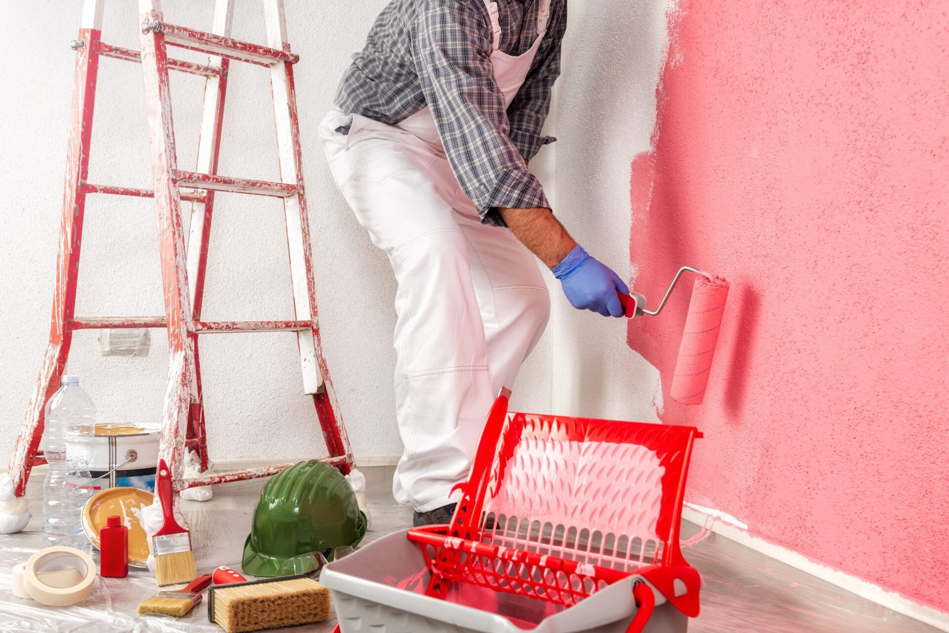 worker in white work overalls, with the roller painting the wall worker in white work overalls, with the roller painting the wall